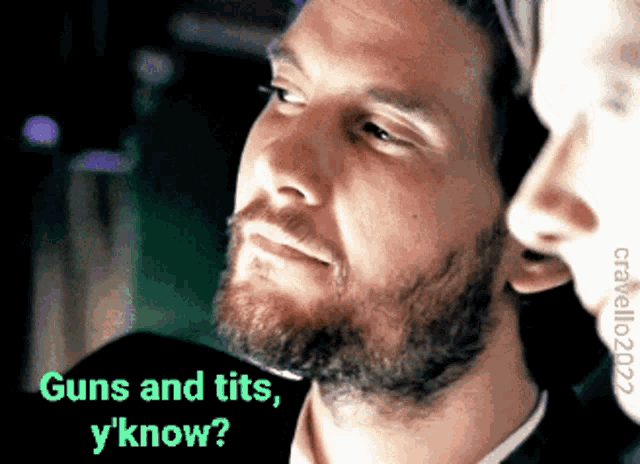 a man with a beard is talking to a woman with the words guns and tits y know