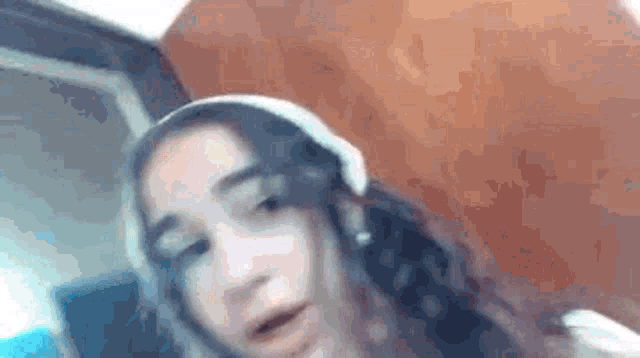 a girl wearing headphones is making a funny face .
