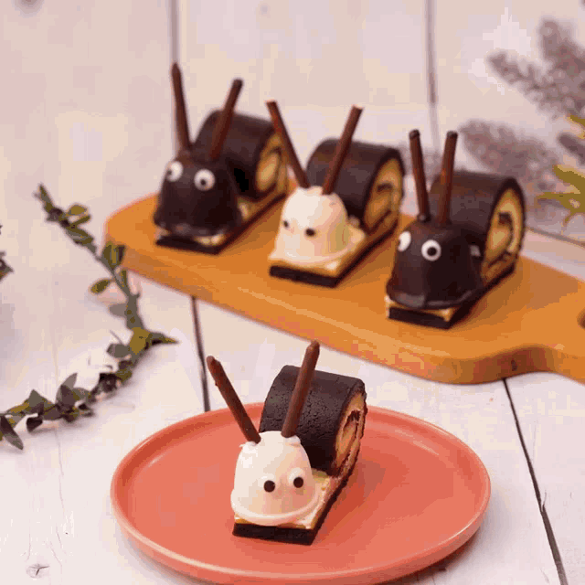 a plate of desserts in the shape of snails on a wooden cutting board