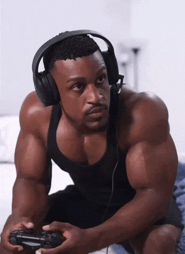 a muscular man wearing headphones and holding a game controller
