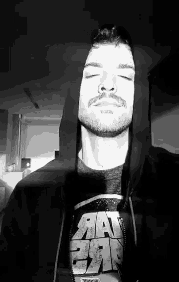 a man with his eyes closed is wearing a t-shirt that says star wars on it