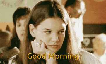 a girl with long hair is saying good morning with her hand on her chin