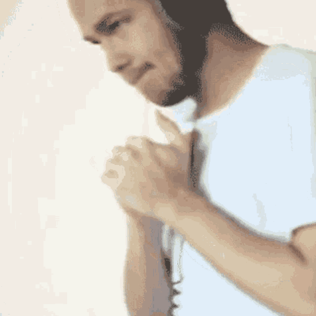 a man in a white shirt is talking on a phone
