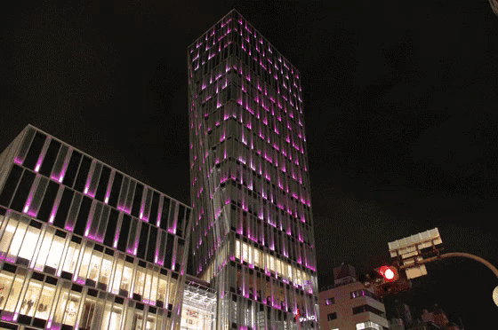 a tall building with purple lights on it