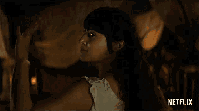 a woman is standing in a dark room with a netflix logo on the bottom right
