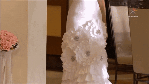 a woman in a wedding dress is standing in front of a sign that says " las estrellas "