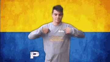 a man wearing a grey shirt with the letter p on the bottom
