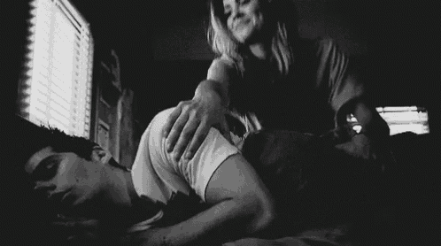 a black and white photo of a woman putting her hand on a man 's butt .
