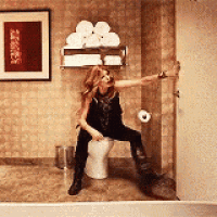 a woman is sitting on a toilet in a bathroom while dancing .