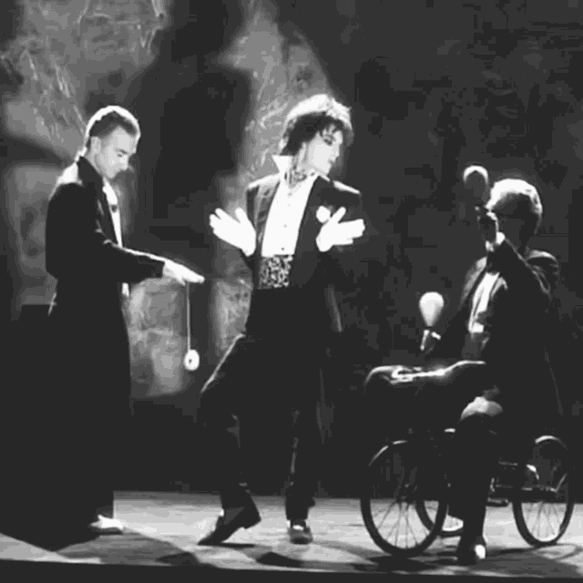 a man in a wheelchair is being pushed by two men in suits