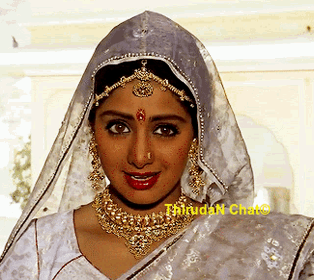 a close up of a woman wearing a veil and a necklace with the words thirudan chat written on the bottom