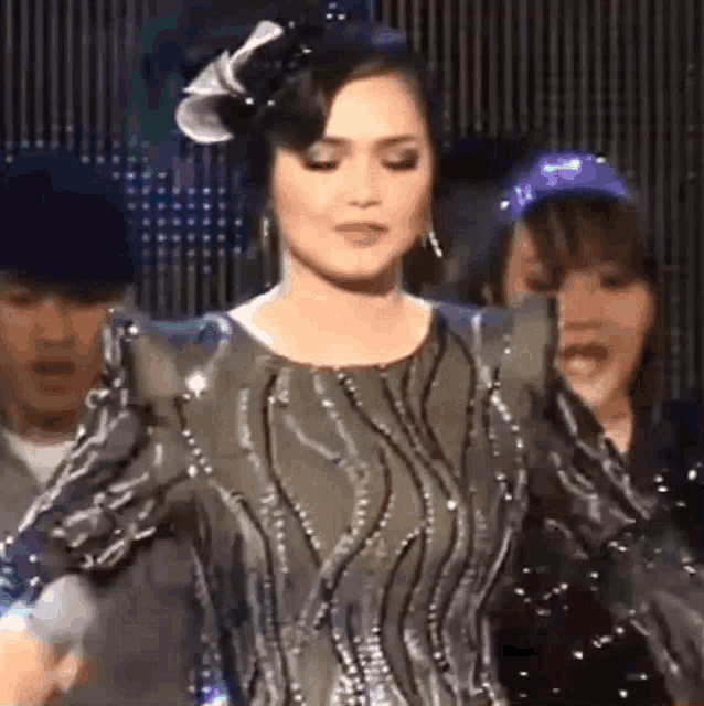 a woman in a sequined dress is dancing on a stage with a microphone .