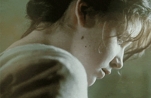 a close up of a woman 's face with a bun