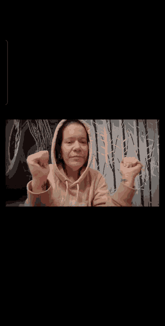 a woman covering her mouth with her hands in front of a clock