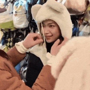 a woman wearing a white bear hat is being touched by a man