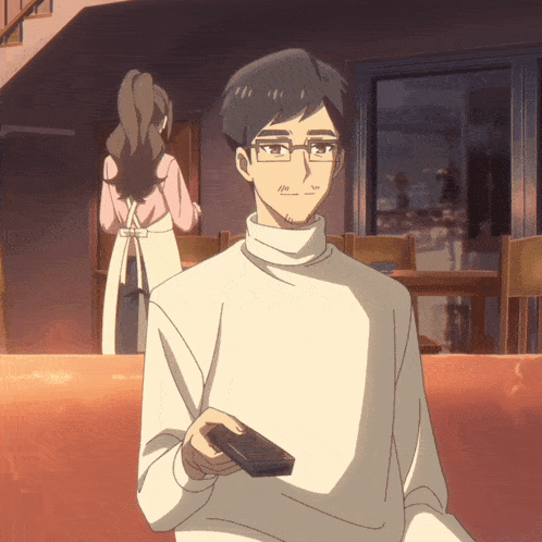 a man in a white sweater is holding a remote control in his hand