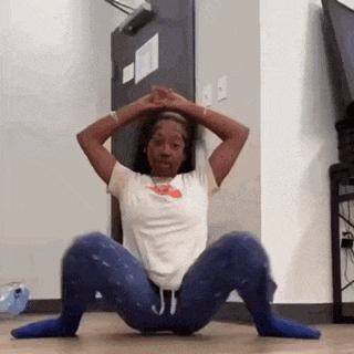 a woman is doing squats on the floor in a room .