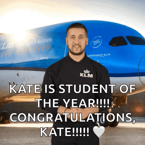 a man wearing a klm shirt stands in front of a klm plane
