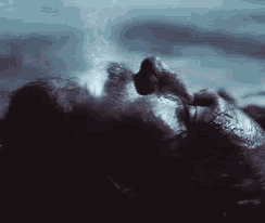 a man is laying in the water with his eyes closed .