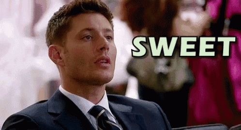 a man in a suit and tie is sitting in a chair in front of a sign that says `` sweet '' .