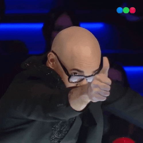 a bald man with glasses is giving a thumbs up sign