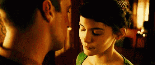 a man and a woman are looking at each other and kissing .