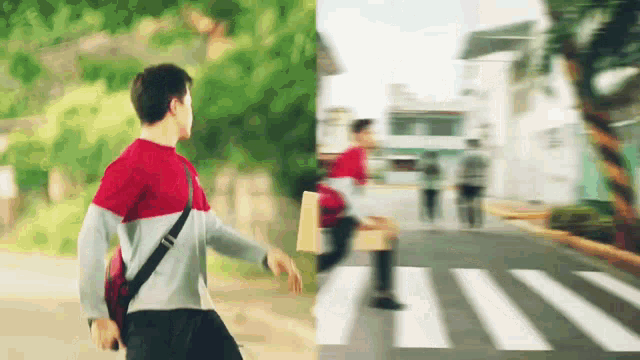 a man in a red shirt is walking down a street