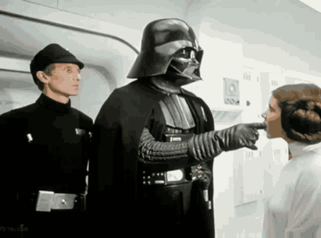 a man in a darth vader costume points at a woman in a white dress