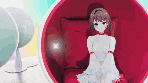 a girl is sitting in a red chair with a white top on