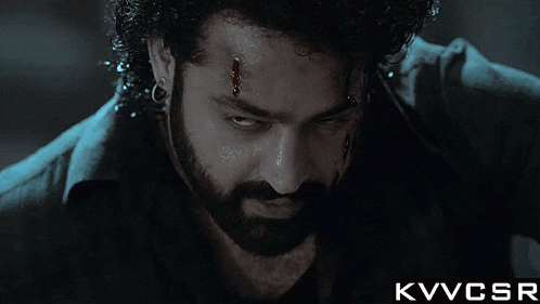 a man with a beard has a bloody spot on his forehead and the words kvvcsr below him