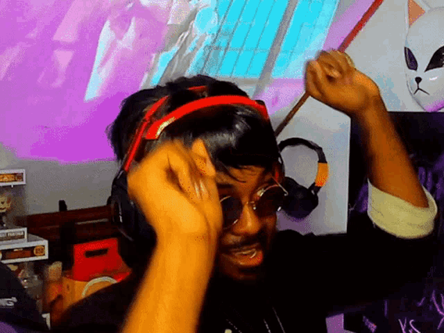 a man wearing headphones and sunglasses is dancing in front of a funko pop