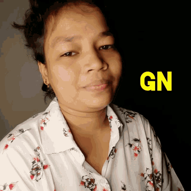a woman wearing a floral shirt with the word gn on the bottom
