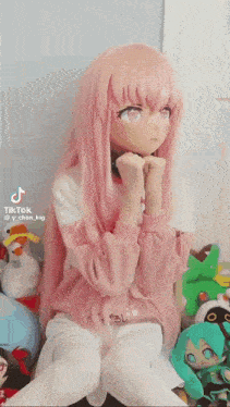 a girl wearing a pink wig and a mask is sitting on a couch .