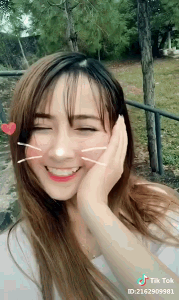 a girl is smiling with her eyes closed and a tik tok id