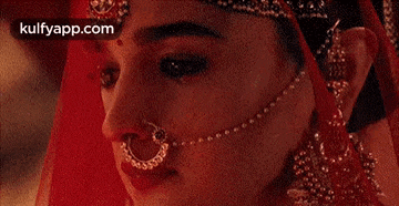 a close up of a woman 's face with a nose ring and a veil .