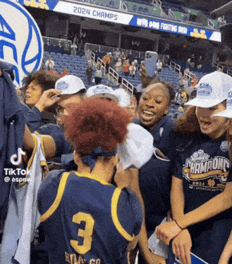 a group of people in a stadium with a sign that says 2024 champs behind them
