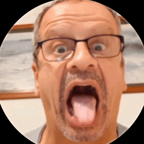 a man with glasses and a beard is making a funny face