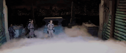 a group of people are standing in a room with smoke coming out of the door .