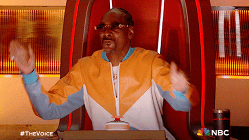 snoop dogg is sitting in a chair with his arms outstretched and a nbc logo in the corner