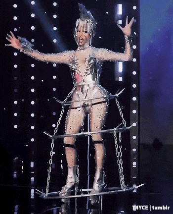 a woman in a costume with chains around her legs is on a stage with a tumblr logo in the corner