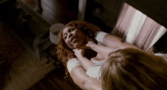 a woman is choking another woman in a mirror