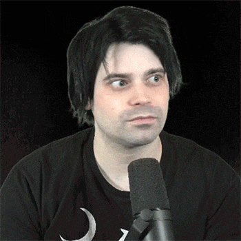a man in a black shirt with a crescent moon on it is talking into a microphone