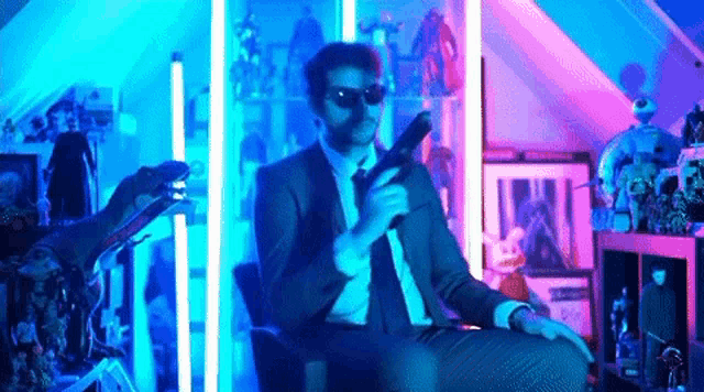 a man in a suit and tie is holding a gun in a room filled with lots of action figures .