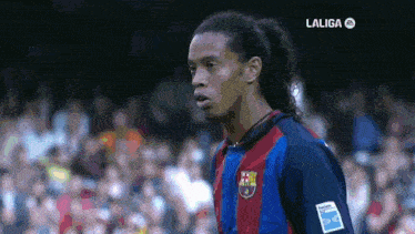 a soccer player stands in front of a crowd with laliga on the bottom left