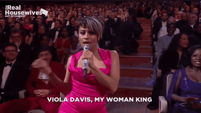 a woman singing into a microphone with the words viola davis my woman king on the screen