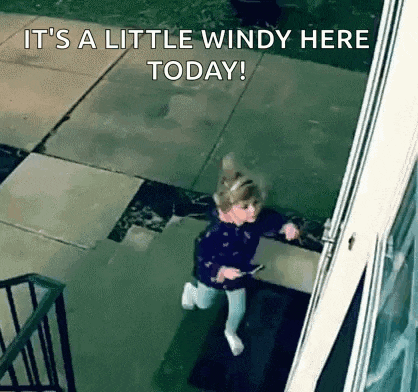 a little girl is running down a sidewalk in the rain .