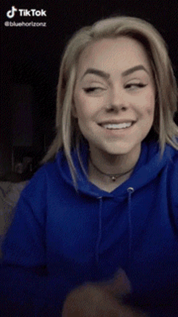 a woman wearing a blue hoodie has a tiktok watermark on the bottom right