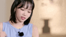 a close up of a woman wearing a blue tank top with a microphone .