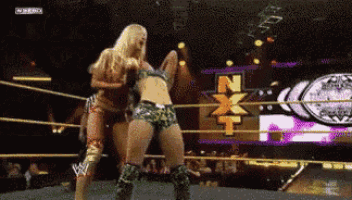 two women are wrestling in a ring with a nxt logo behind them