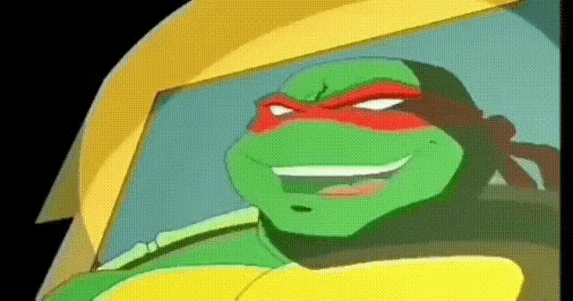 a close up of a teenage mutant ninja turtle wearing a yellow helmet and smiling .